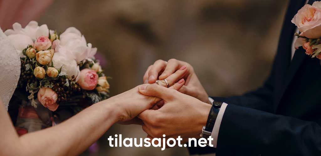 Lähikuva morsiusparin käsistä sulhanen laittaa sormusta morsiamelle - Tilausajot.net