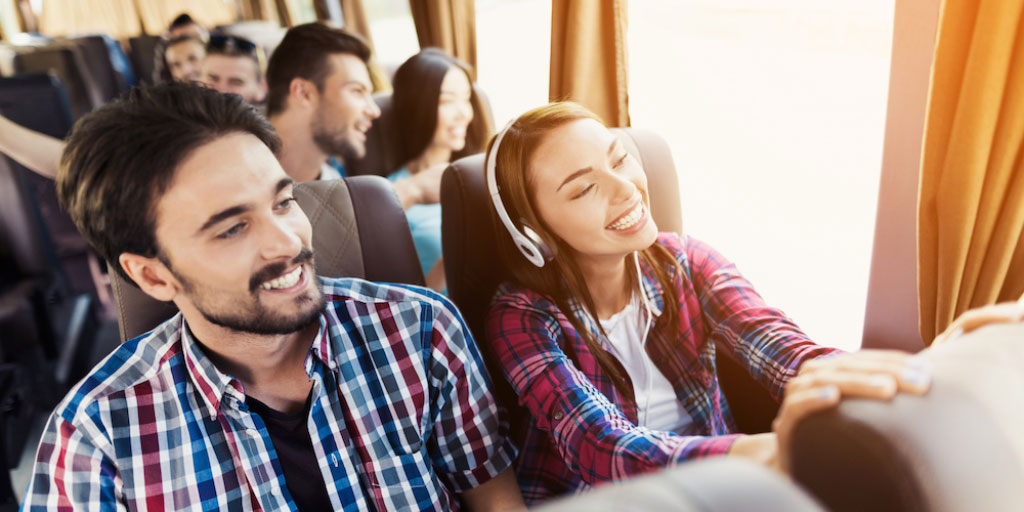 Bussissa tilausajomatkustajat hymyilevät - Tilausajot.net