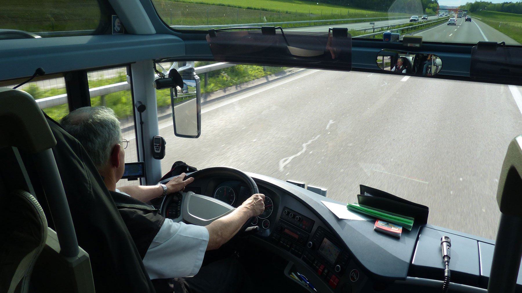 mieskuljettaja ajaa isoa linja-autoa